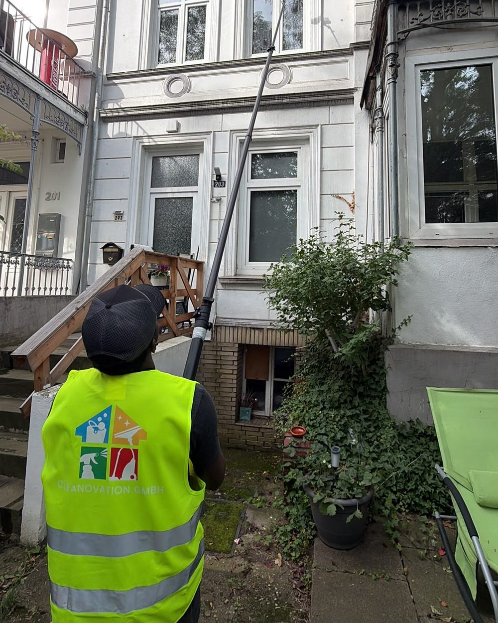 Cleanovation Mitarbeiter bei der Fensterreinigung mit Osmose-Teleskopstange in Hamburg